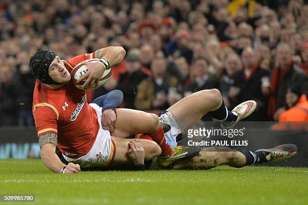Wales' wing Tom James is tackled by Scotland's centre Duncan Taylor just before the try line during the Six Nations international rugby union match...