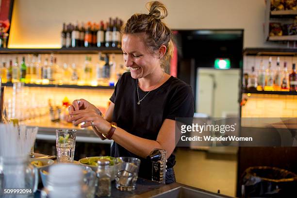 female bar tender behind bar making a drink - australian pub stock pictures, royalty-free photos & images