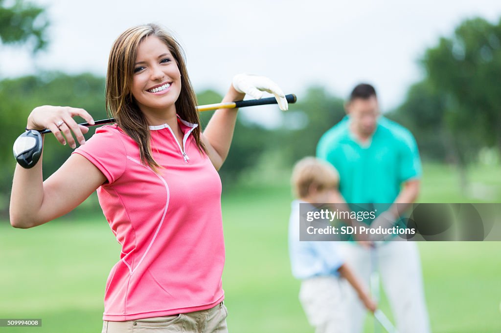 Woman playing golf with family