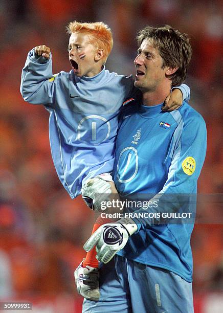 Dutch goalkeeper Edwin Van Der Sar celebrates with his child, 26 June 2004 at the Algarve stadium in Faro, at the end of the Euro 2004 quarter final...