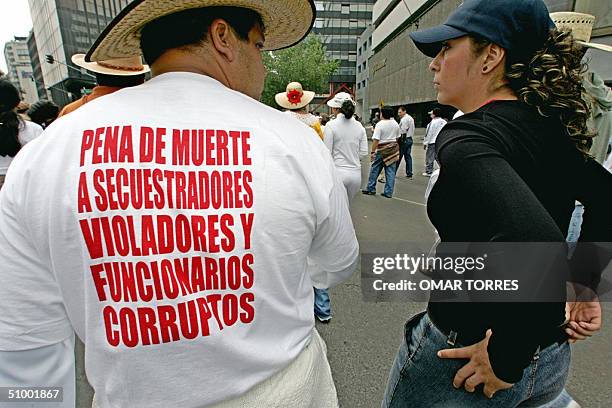 Un hombre y una mujer conversan el 27 de junio de 2004 mientras participan en una multitudinaria marcha por la calles de Ciudad de Mexico contra los...