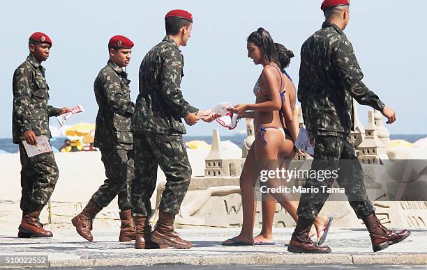 Brazilian Army soldiers pass out pamphlets on Copacabana beach warning of the dangers of the Zika virus and how to protect against mosquitos on...