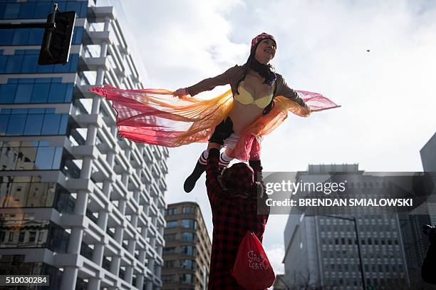 Man holds a woman up while running in "Cupid's Undie Run" to raise money for charity on February 13, 2016 in Washington, DC. Participants run in...