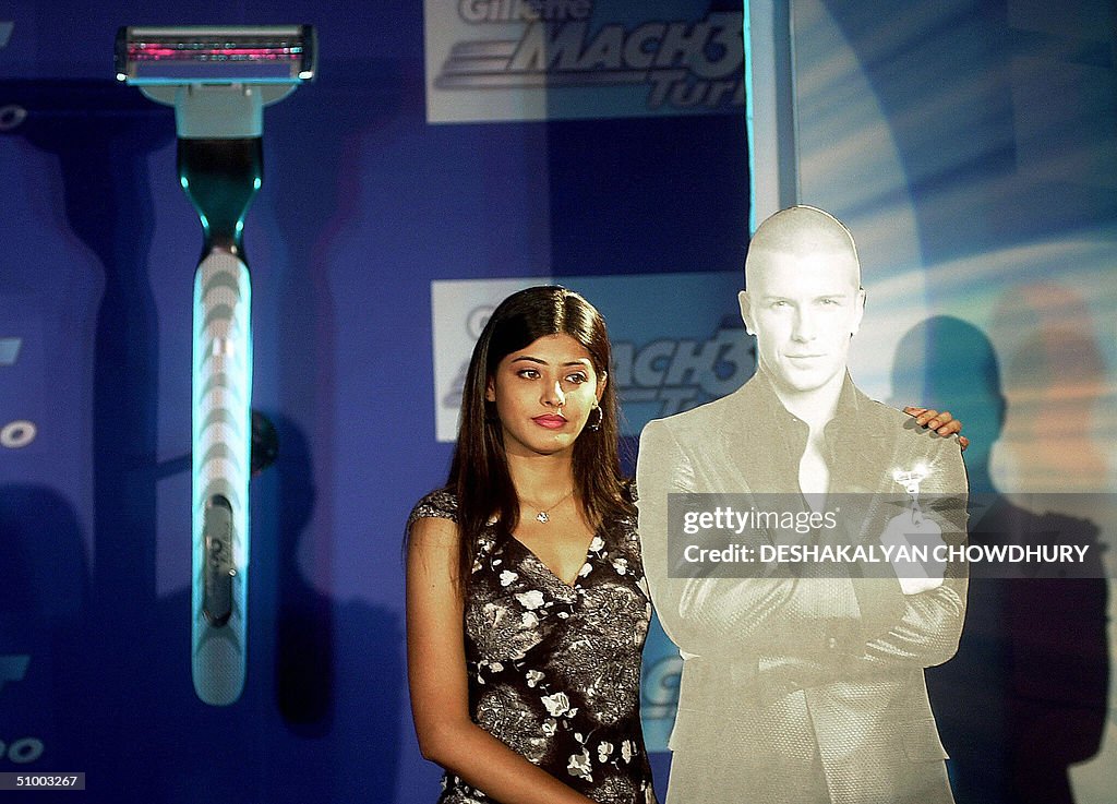 An Indian model poses with a cutout of E