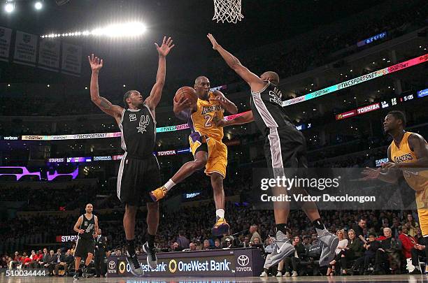 Kobe Bryant of the Los Angeles Lakers looks to make a pass between Kawhi Leonard and Boris Diaw of the San Antonio Spurs during the NBA game at...