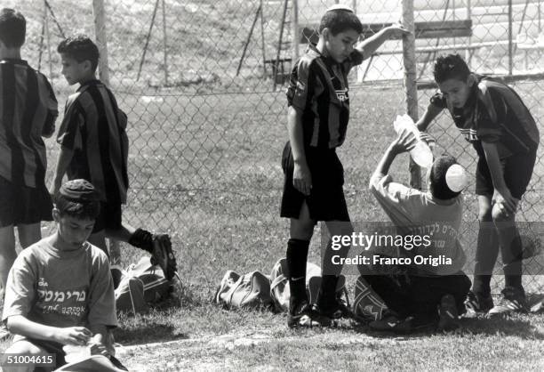 Young footballers involved with Inter Campus Project rest during a training session May 18, 2000 in Afula, Israel. Inter Campus is a social program...