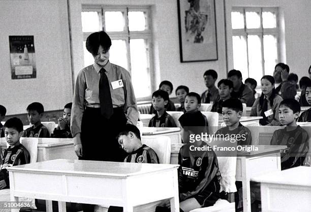 Young footballer involved with Inter Campus Project sleeps during a lesson March 28, 2002 in Qingdao, China. Inter Campus is a social program enacted...