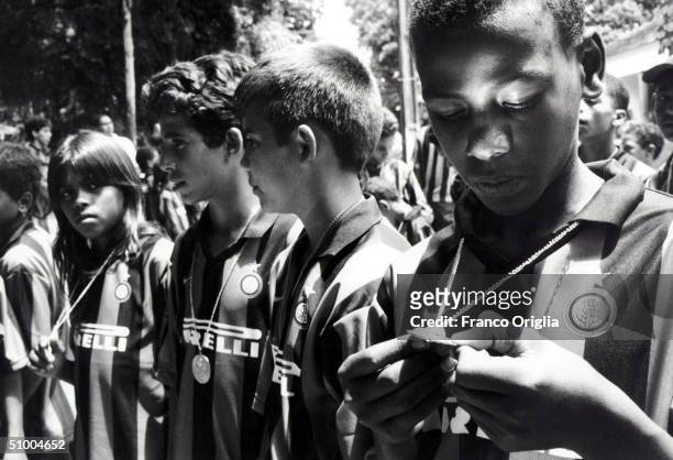Young footballer involved with Inter Campus Project looks at his golden medal, for best Inter Campus player, during a meeting at the Recife Zoo April...