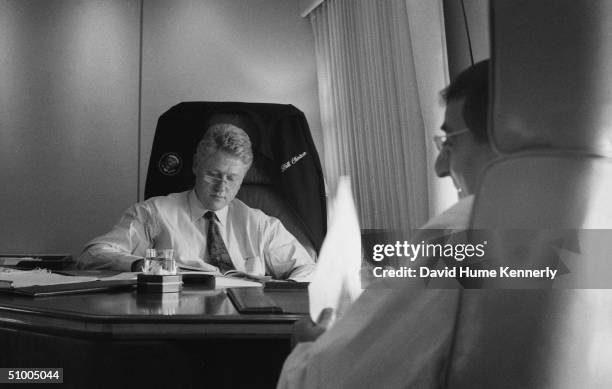 American President Bill Clinton and White House Chief of Staff Leon Panetta work on board Air Force One while enroute to New York City, July 1996.
