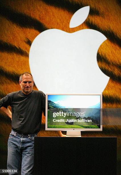 Apple CEO Steve Jobs stands next to a new 30-inch flat panel display as he delivers the keynote address at the 2004 Worldwide Developers Conference...