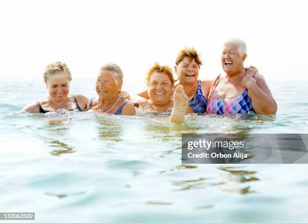 ältere frauen lachen am strand - old woman in swimsuit stock-fotos und bilder