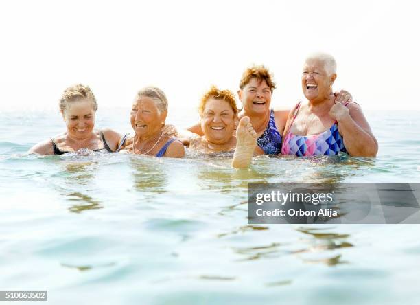 mature ladies laughing on beach - middle aged woman bathing suit stock pictures, royalty-free photos & images