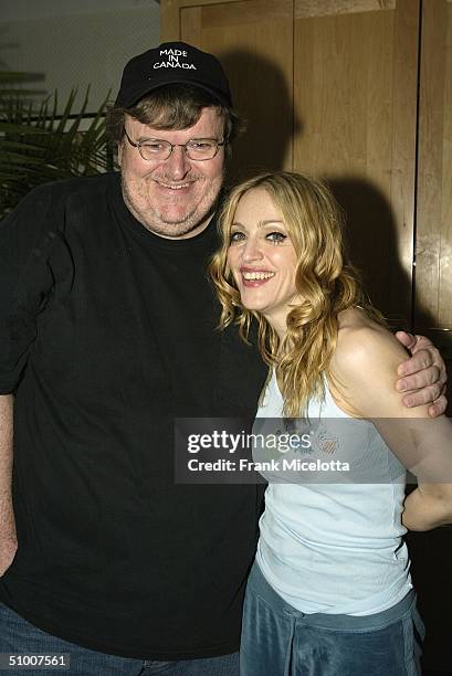 Singer Madonna and director Michael Moore pose backstage during Madonna's "Re-Invention" World Tour 2004 at Madison Square Garden June 16, 2004 in...