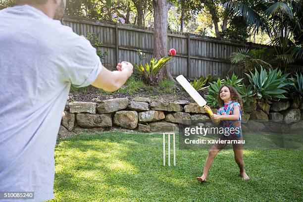 father and daughter playing cricket in the garden - family cricket stockfoto's en -beelden