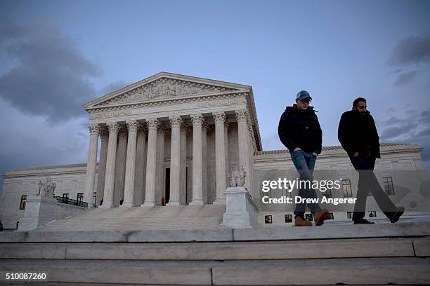 Visitors walk by the U.S. Supreme Court is seen at dusk February 13, 2016 in Washington, DC. Supreme Court Justice Antonin Scalia was at a Texas...