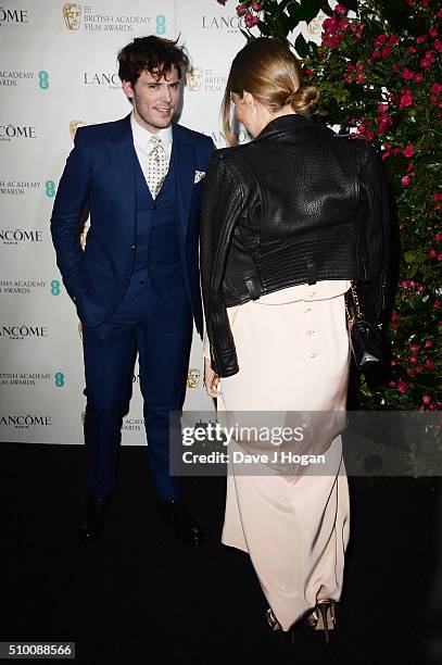 Sam Claflin and Laura Haddock, dress detail, attend the Lancome BAFTA nominees party at Kensington Palace on February 13, 2016 in London, England.