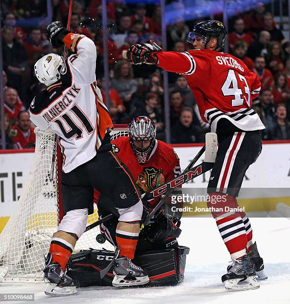 Viktor Svedberg of the Chicago Blackhawks shoves Harry Zolnierczyk of the Anaheim Ducks as Corey Crawford makes a save at the United Center on...