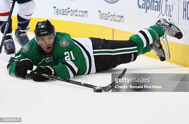 Antoine Roussel of the Dallas Stars falls while skating the puck against John Carlson of the Washington Capitals in the first period at American...