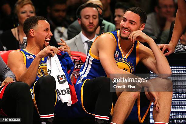 Stephen Curry and Klay Thompson of the Golden State Warriors laugh on the bench in the Foot Locker Three-Point Contest during NBA All-Star Weekend...