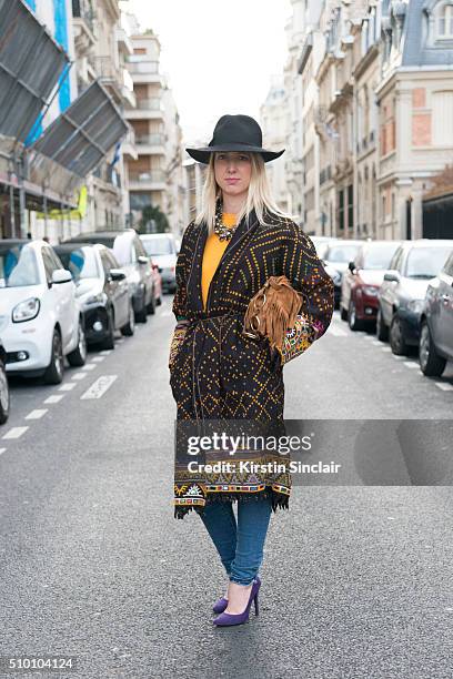 Fashion editor Camille Vincent wears an Isabel Marant coat, Yves Saint Laurent bag, Castaner shoes and Topshop hat on day 3 of Paris Haute Couture...