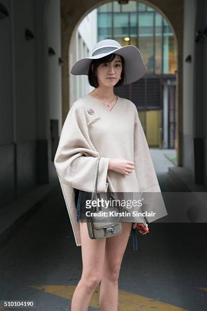 Student Peiyao Liu wears a Celine poncho, Zara shorts, Chanel brooch, Maison Michel hat, and a Hermes bag on day 3 of Paris Haute Couture Fashion...