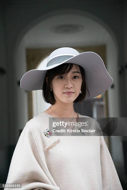 Student Peiyao Liu wears a Celine poncho, and Maison Michel hat on day 3 of Paris Haute Couture Fashion Week Spring/Summer 2016, on January 26, 2015...