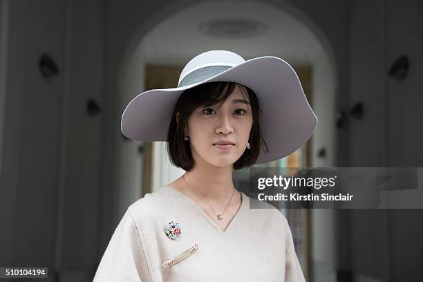 Student Peiyao Liu wears a Celine poncho, and Maison Michel hat on day 3 of Paris Haute Couture Fashion Week Spring/Summer 2016, on January 26, 2015...