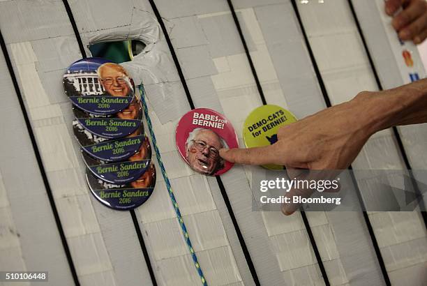 An attendee points to a campaign button for Senator Bernie Sanders, an independent from Vermont and 2016 Democratic presidential candidate, during a...