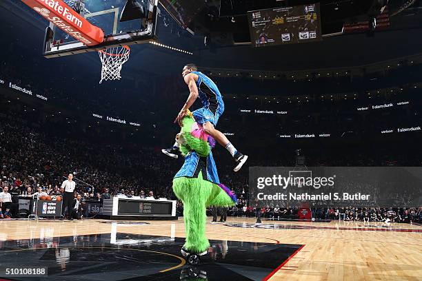 Aaron Gordon of the Orlando Magic dunks over the stuff the magic dragon, the mascot of the Orlando Magic during the Verizon Slam Dunk Contest during...