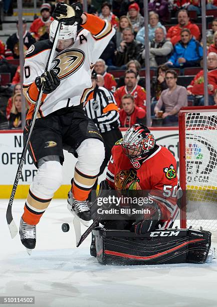 Corey Perry of the Anaheim Ducks jumps out of the way of the puck in front of goalie Corey Crawford of the Chicago Blackhawks, resulting in the...