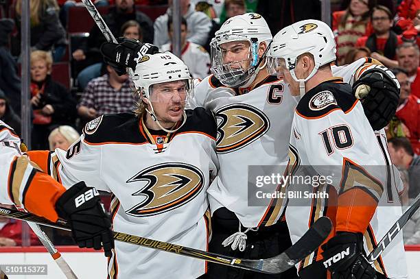 Ryan Getzlaf of the Anaheim Ducks celebrates with Sami Vatanen and Corey Perry after scoring the game winning goal in overtime, resulting in a 3 to 2...