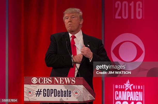 Republican presidential candidates Donald Trump tucks a note into his suit pocket following the CBS News Republican Presidential Debate in...