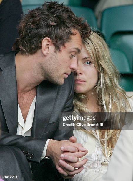 Actor Jude Law and actress Sienna Miller watch the quarter final match between Lleyton Hewitt of Australia and Roger Federer of Switzerland at the...