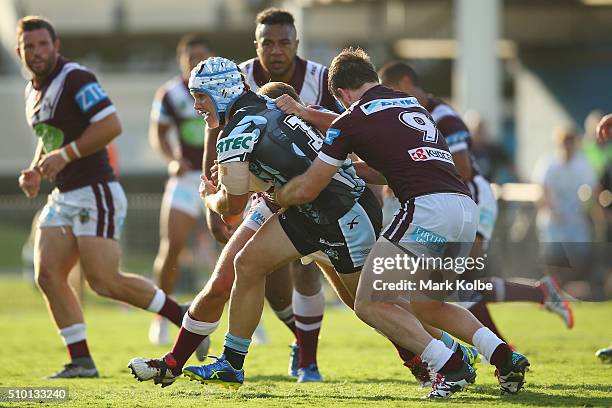 Josh Cleeland of the Sharks is tackled during the NRL Trial match between the Cronulla Sharks and the Manly Sea Eagles at Remondis Stadium on...