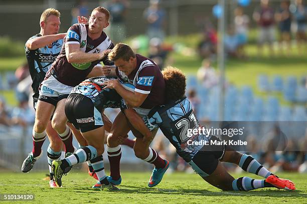 Luke Lewis of the Sharks and Tom Symonds of the Eagles collide as Liam Knight of the Eagles is tackled during the NRL Trial match between the...