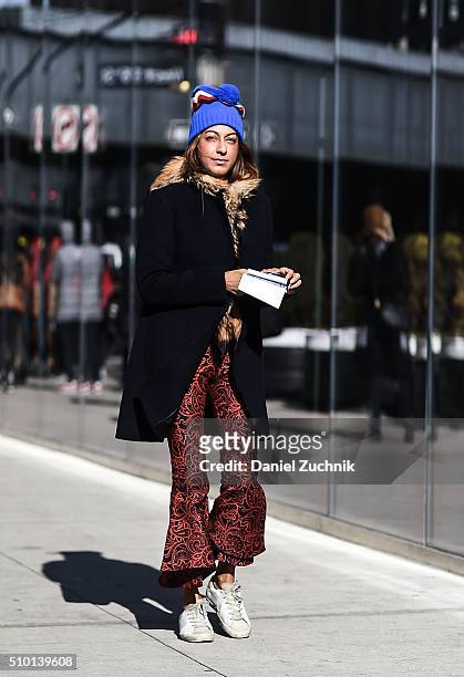 Ramya Giangola is seen outside the Tibi show wearing a Celine blue with fur trim coat and Golden Goose sneakers during New York Fashion Week: Women's...