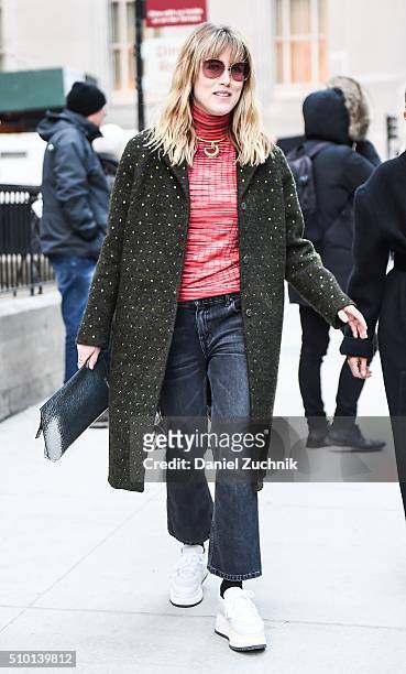 Annabel Rosendahl is seen outside the Alexander Wang show wearing a forest green coat with blue jeans, white shoes and red sweater during New York...
