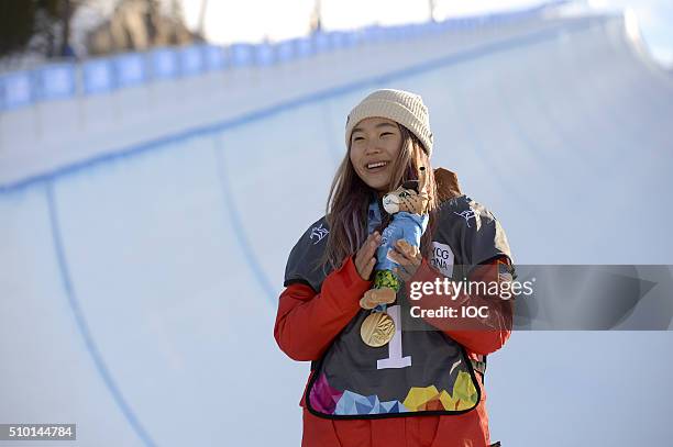 In this handout image supplied by the IOC, Chloe Kim of the United States poses on the medal podium after winning the Ladies' Snowboard Halfpipe...