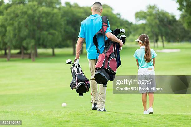 father and daughter walk on golf course - golf accessories stock pictures, royalty-free photos & images