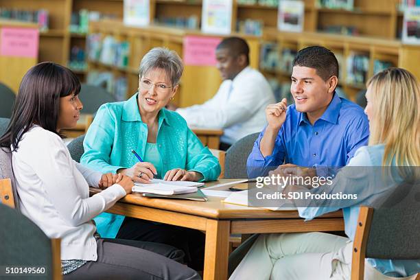 group of teachers meet in library - book club meeting stockfoto's en -beelden