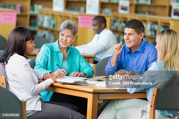 group of teachers meet in library - book club meeting stock pictures, royalty-free photos & images