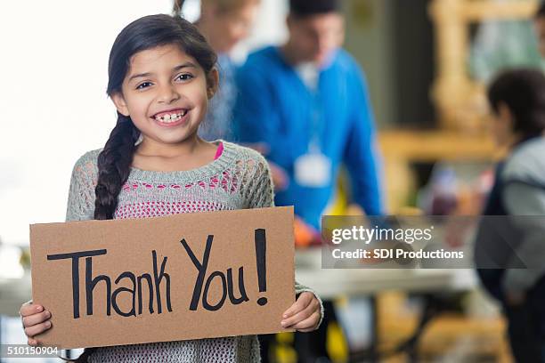 hermosa chica hispana es " ¡ gracias!" señal en cocina libre - help single word fotografías e imágenes de stock