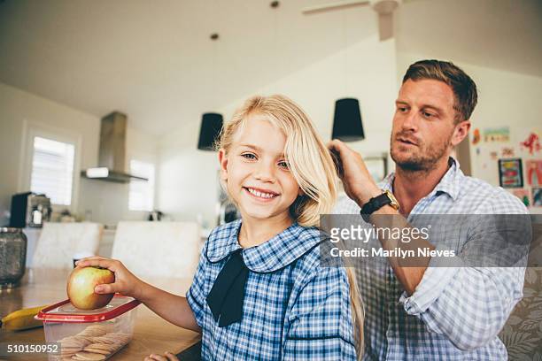 dad combing daughter's hair for school - parent daughter school uniform stock pictures, royalty-free photos & images