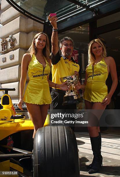 Eddie Jordan, team owner of the Jordan F1 Team, and F1 glamour girls Michelle Clack and Leah Newman, pose on a Jordan F1 car outside the Austin Reed...