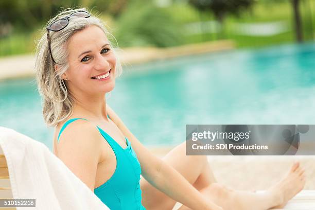 schöne leitender frau entspannung am swimmingpool - old woman in swimsuit stock-fotos und bilder