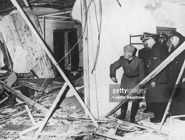 Benito Mussolini and Adolf Hitler inspect the wreckage of the conference room in Hitler's headquarters following a failed bombing assassination...