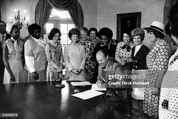 American President Gerald Ford signs legislation declaring August 26th Women's Equality Day, Washington DC, August 22, 1974. Also present are, from...