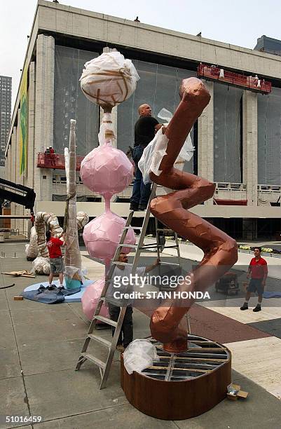 Michael DeSanctis takes the final wrapping off the aluminum sculpture, "Bronze", by Austrian artist Franz West, 01 July in front of Lincoln Center in...