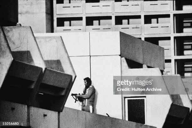 An armed German policeman stands on the roof of a dormitory where members of the Black September terrorist group had earlier captured and were...