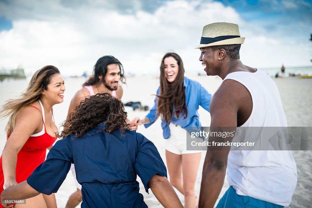 Grupo de amigos sosteniendo las manos en la playa